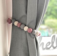 a curtain with some balls on it in front of a window