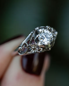 A close-up image of an antique Art Deco era floral engagement ring. This 14K white gold engagement ring features a 0.66ct round natural diamond center stone and floral filigree. Elk Antler Wedding Band, Antler Wedding Rings, Antler Wedding Band, Ruby Wedding Band, Agate Engagement Ring, Gold Art Deco, Handcrafted Rings, Gold Art, Antique Engagement Rings