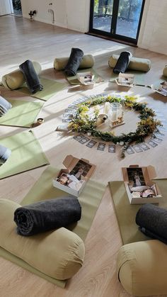 a group of people sitting on yoga mats in the middle of a room with pictures and candles