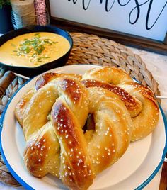 two pretzels are on a plate next to a bowl of soup