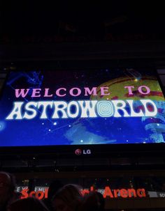 the welcome to astroworld sign is lit up in front of people at an event