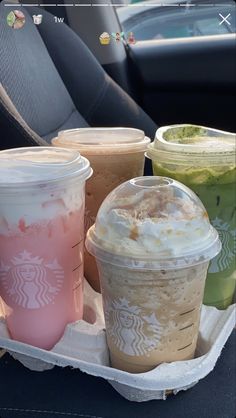 starbucks drinks are sitting on a tray in the back seat of a car, ready to be eaten