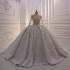 a wedding dress on display in a white room