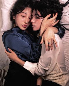 two women hugging each other while laying in bed