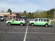 two cars parked in a parking lot with trees in the backgrouds and one car painted green