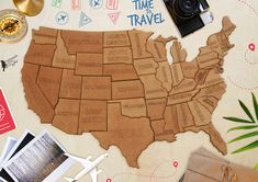 a wooden united states map with magnets and pictures on the table next to it