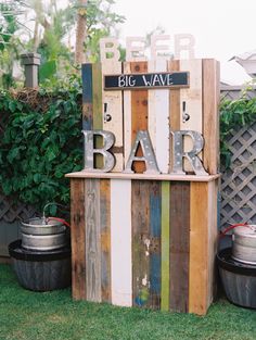 an outdoor bar made out of pallets and wooden planks with the word big wave written on it