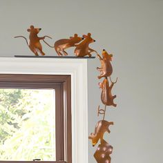 three metal mice on top of a window sill in front of a white wall