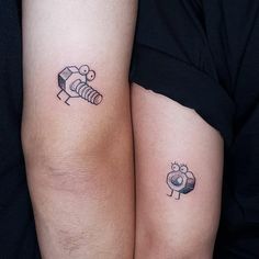 two people with matching tattoos on their arms, one has a bee and the other has a robot