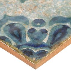 a close up view of a tile with blue and green designs on it's surface