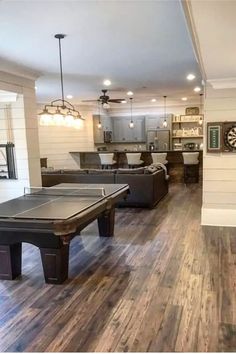 a living room filled with furniture and a pool table