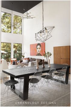 a dining room table with four chairs and a painting on the wall above it that reads urbanlogy designs