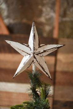 a wooden star ornament hanging from a christmas tree