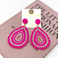 Sound Wave Beaded Drop Earrings with Clear Crystals in Fuchsia. Pictured on a white background with a book behind it. Pink Teardrop Beaded Earrings For Party, Trendy Teardrop Beaded Earrings, Trendy Pink Beaded Earrings For Spring, Trendy Pink Beaded Drop Earrings, Graphic Tee And Jeans, Beaded Teardrop Earrings, Sound Wave, Giddy Up Glamour, Beaded Drop Earrings