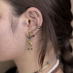 a close up of a person with ear piercings on their ears and behind the ear