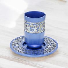 a blue cup and saucer sitting on top of a wooden table