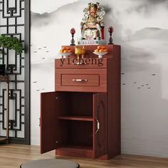 there is a cabinet in the room with buddha statue on top and other decorations around it