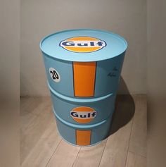 a blue and orange cooler sitting on top of a wooden floor next to a wall