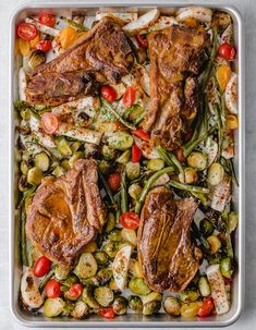 a tray filled with meat and vegetables on top of a table