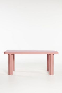 a pink bench sitting on top of a white floor