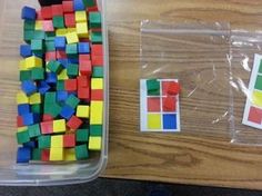 a plastic container filled with lots of colored blocks next to a bag of stickers