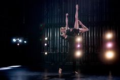 two dancers are performing on stage in the dark