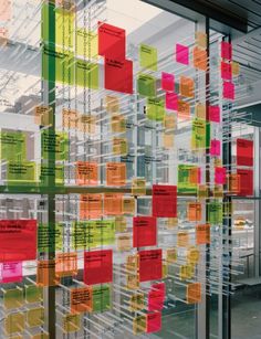 an office building with colorful sticky notes attached to the glass walls