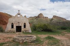 an old church in the middle of nowhere with mountains in the backgrouds