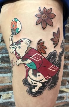 a tattoo on the leg of a person with an animal holding a soccer ball in it's hand