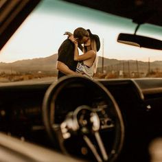 a man and woman are kissing in the back seat of a car while another person is driving behind them