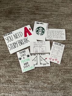 several starbucks stickers are on the floor next to some papers with words and symbols