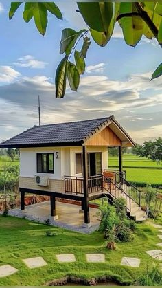 a small house sitting on top of a lush green field