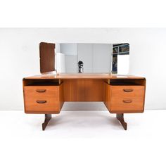 a wooden desk with two drawers and a mirror