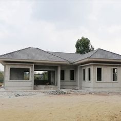 a house under construction in the middle of a field with dirt and rocks on the ground