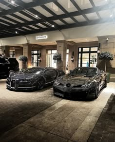 two black sports cars parked in front of a building