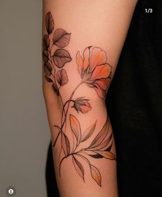 a woman's arm with flowers and leaves on it