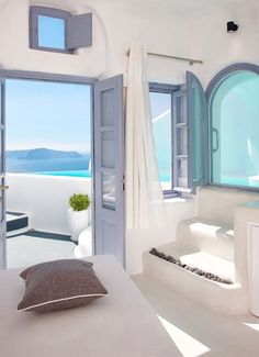 a bedroom with an open door leading to the ocean