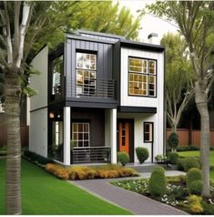 a two story house with black and white sidings on the front, trees in the back