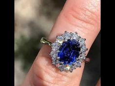 a woman's engagement ring with an oval blue sapphire surrounded by diamonds