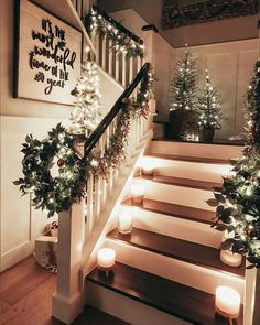 stairs decorated with christmas lights and greenery for the holiday season, lit by candles