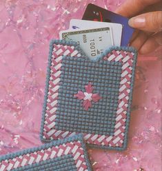 two handmade purses with pink and blue designs on them, one has a credit card in it