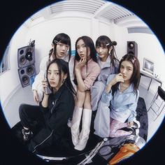 a group of young women sitting next to each other in front of a speaker system