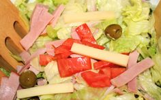 a salad with ham, lettuce and olives