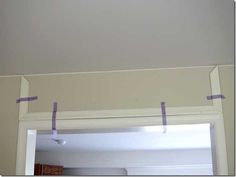 some purple tape is taped to the ceiling above a mirror in a room with white walls