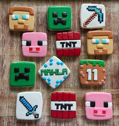 decorated cookies are arranged in the shape of minecraft characters on a wooden table top