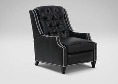 a black leather chair with studded trimmings on the arm and backrest