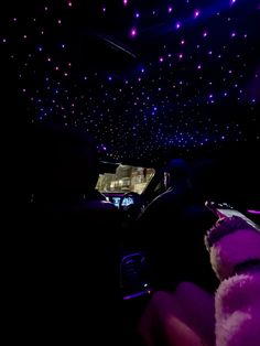 the interior of a car is lit up with purple lights and stars on the ceiling