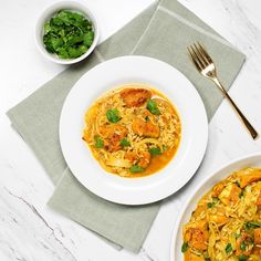 a plate of pasta with shrimp and spinach on it next to a bowl of greens