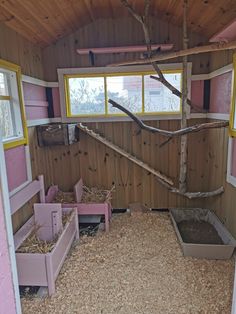 the inside of a barn with wooden walls and flooring, including pink benches and windows