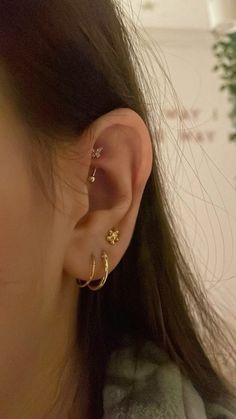 a close up of a person's ear with two small gold rings on it